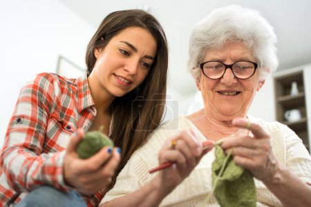 Foto de Nieta aprendiendo a tejer de su abuela. - Imagen libre de derechos