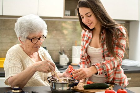 Téléchargez les photos : Grand-mère et petite-fille cuisinent dans la cuisine
. - en image libre de droit
