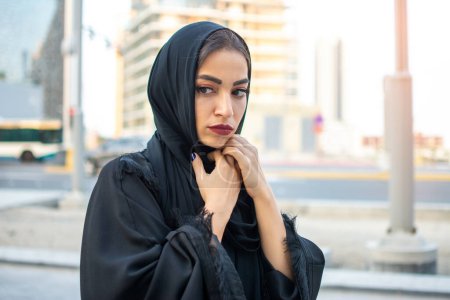 Téléchargez les photos : Belle jeune femme arabe effrayée portant des vêtements arabes traditionnels dans la rue - en image libre de droit
