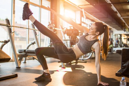 Téléchargez les photos : Belle forme sportive femme faisant de l'exercice dans la salle de gym. - en image libre de droit