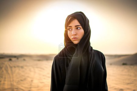 Portrait de belle femme arabe dans le désert au coucher du soleil