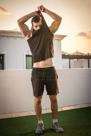 Foto de Hombre guapo quitándose la camisa al aire libre - Imagen libre de derechos