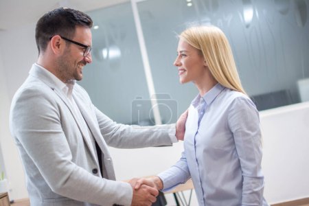 Foto de Mujer de negocios y hombre estrechando la mano después de una reunión exitosa en la oficina - Imagen libre de derechos