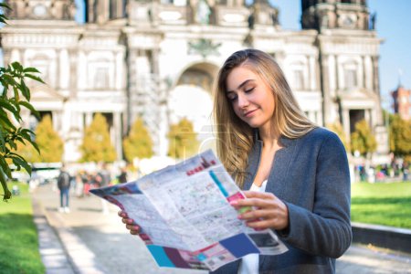 Téléchargez les photos : Jeune femme avec carte à la recherche d'attractions de la ville en plein air - en image libre de droit