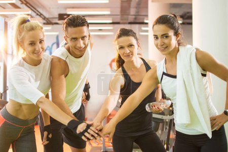 Photo for Group of fitness people stacking hands in the gym. Concept of teamwork, leadership and success - Royalty Free Image