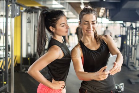 Photo for Two female friends taking a selfie photo after hard workout in gym - Royalty Free Image