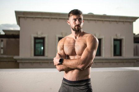 Photo for Confident shirtless young man standing with arms crossed outdoors - Royalty Free Image