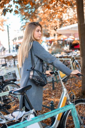 Junge Frau mit Fahrrad versucht, dem Stadtverkehr auszuweichen. Mädchen nimmt ein Fahrrad zum Ausleihen