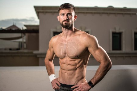 Photo for Sexy athletic man showing muscular body and six-pack abs outdoors - Royalty Free Image