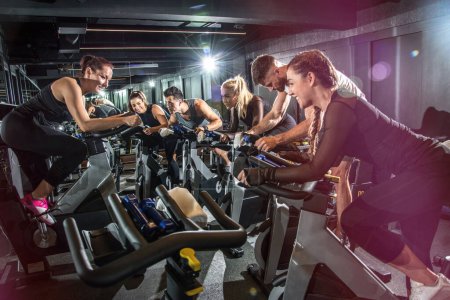 Group of fit people cycling in fitness club