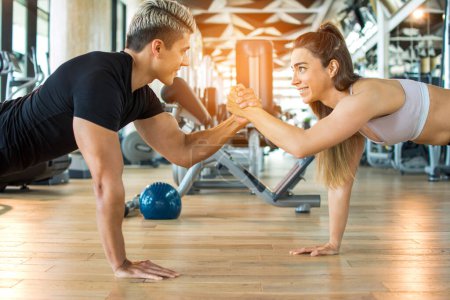 Photo for Young muscular sporty couple working out together at the gym - Royalty Free Image