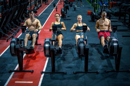 Foto de Grupo de deportistas haciendo ejercicio en los remeros del gimnasio - Imagen libre de derechos