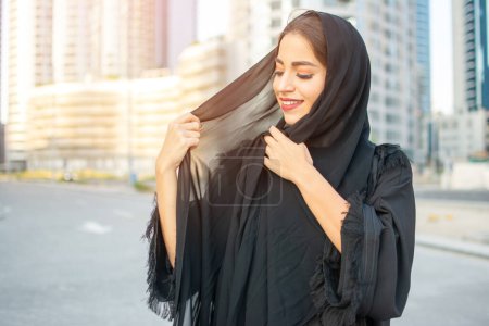 Téléchargez les photos : Portrait de belle femme du Moyen-Orient portant abaya dans la rue - en image libre de droit
