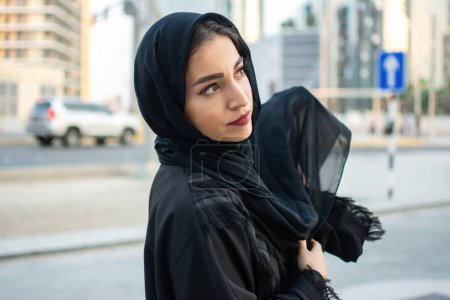 Téléchargez les photos : Portrait de belle femme arabe du Moyen-Orient portant abaya dans la rue - en image libre de droit