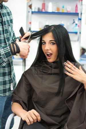 Téléchargez les photos : Surprise fille assise dans le salon de coiffure - en image libre de droit