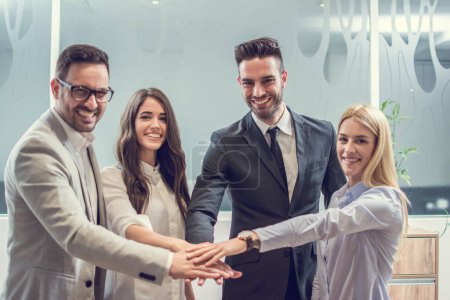 Foto de Grupo de cuatro personas de negocios que se apilan las manos en la oficina - Imagen libre de derechos