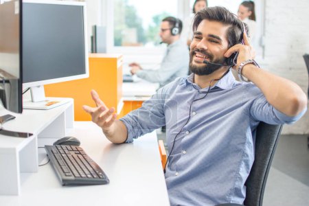 Smiling sales agent with headset talking to client in call centre