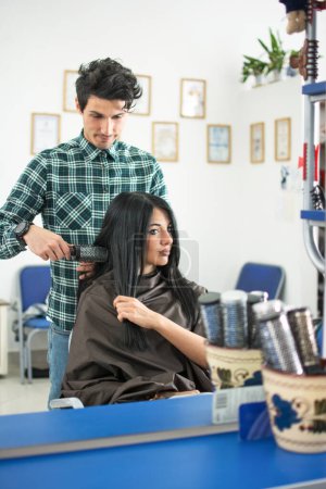 Téléchargez les photos : Miroir reflet de coiffeur professionnel travaillant dans le salon de coiffure - en image libre de droit