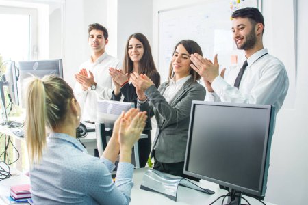 Cheerful business people applauding at business meeting in office