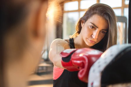 Téléchargez les photos : Mignon brunette femme formation avec sparring partenaire à la salle de gym - en image libre de droit