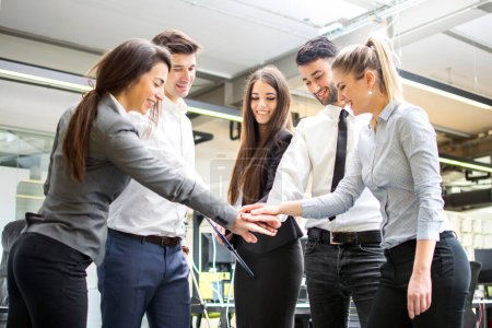 Photo for Business team joining hands together in the office - Royalty Free Image