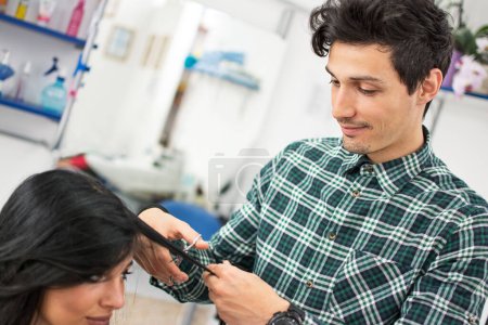 Photo for Young male hairdresser cutting hair with scissors - Royalty Free Image