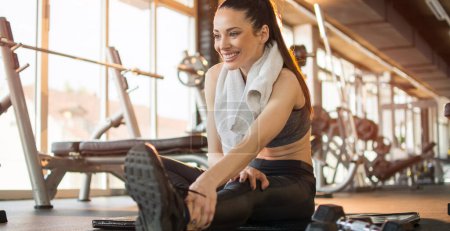 Photo for Fitness sportswoman stretching in the gym. - Royalty Free Image