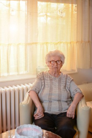Foto de Retrato de una mujer mayor sentada en un sillón en la sala de estar. - Imagen libre de derechos