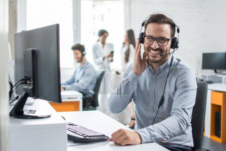 Photo for Smiling friendly handsome young male call centre operator. - Royalty Free Image