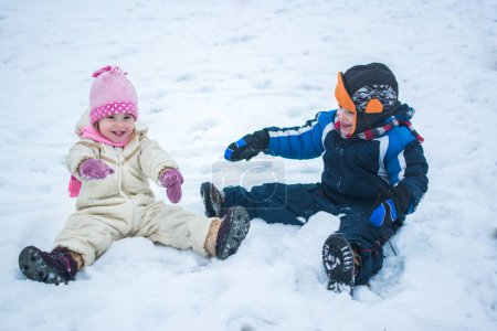 Foto de Niños felices jugando en la nieve en vacaciones de invierno - Imagen libre de derechos