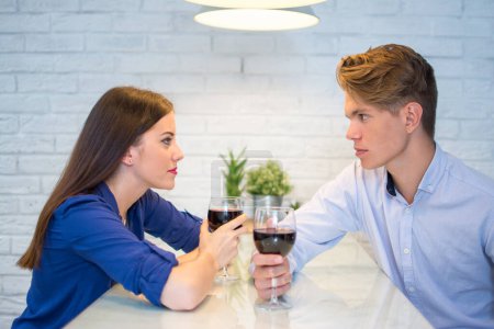 Téléchargez les photos : Jeune couple buvant du vin rouge et flirtant dans la cuisine à la maison - en image libre de droit