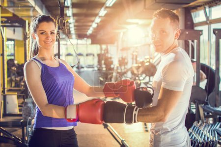 Photo for Young couple posing with red boxing gloves at the gym - Royalty Free Image