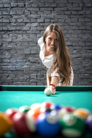 Photo for Cheerful young woman playing billiards. - Royalty Free Image