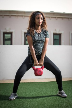 Photo for Beautiful sportswoman workout with kettlebell outdoors. - Royalty Free Image