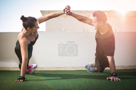 Téléchargez les photos : Jeune couple sportif travaillant ensemble à la salle de gym extérieure. - en image libre de droit