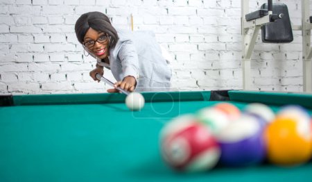 Beautiful young woman playing pool game.