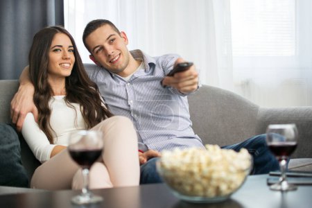 Photo for Young couple watching tv together at home - Royalty Free Image