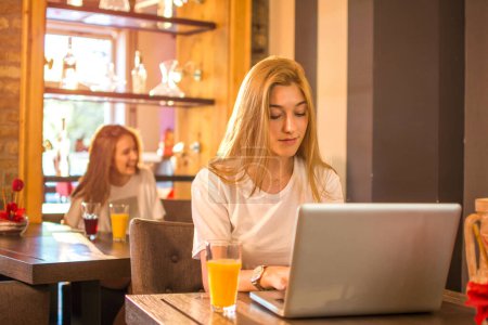 Photo for Teenage girl working at her laptop in cafe - Royalty Free Image