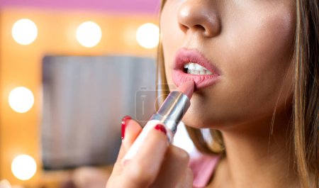 Foto de Primer plano de una mujer poniendo lápiz labial en sus labios. - Imagen libre de derechos