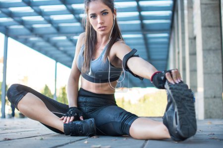 Sporty woman stretching hamstring leg muscles during outdoor workout