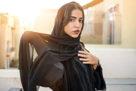 Foto de Retrato de una hermosa mujer joven árabe de oriente medio que usa ropa árabe tradicional durante la puesta del sol al aire libre. - Imagen libre de derechos