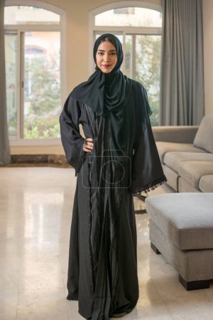Téléchargez les photos : Portrait complet de la jeune femme musulmane en hijab debout à la maison. - en image libre de droit