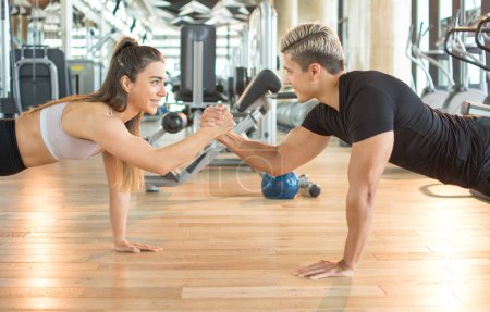 Photo for Young muscular sporty couple working out together at the gym. - Royalty Free Image