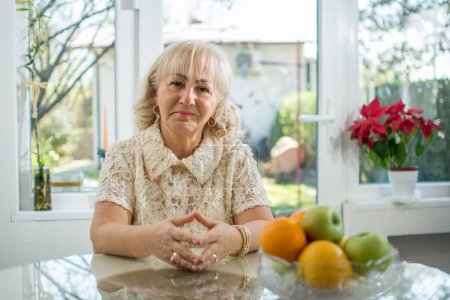 Photo for Portrait of beautiful senior woman sitting at table at home - Royalty Free Image