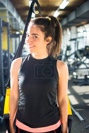 Téléchargez les photos : Portrait de jeune femme tenant la sangle de suspension dans la salle de gym - en image libre de droit