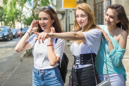 Foto de Grupo de tres adolescentes buscando algo en la calle - Imagen libre de derechos