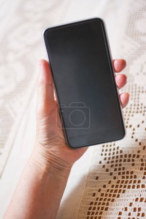 Photo for Close up of old woman hand holding mobile phone - Royalty Free Image