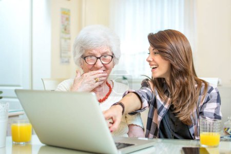 Photo for Granddaughter showing something on laptop to her grandmother - Royalty Free Image