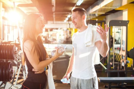Photo for Sporty couple talking after working out at gym - Royalty Free Image