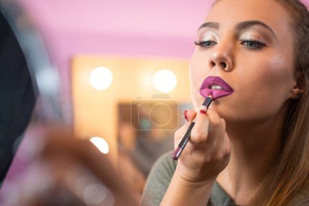 Photo for Beautiful girl applying lip liner to lips. - Royalty Free Image
